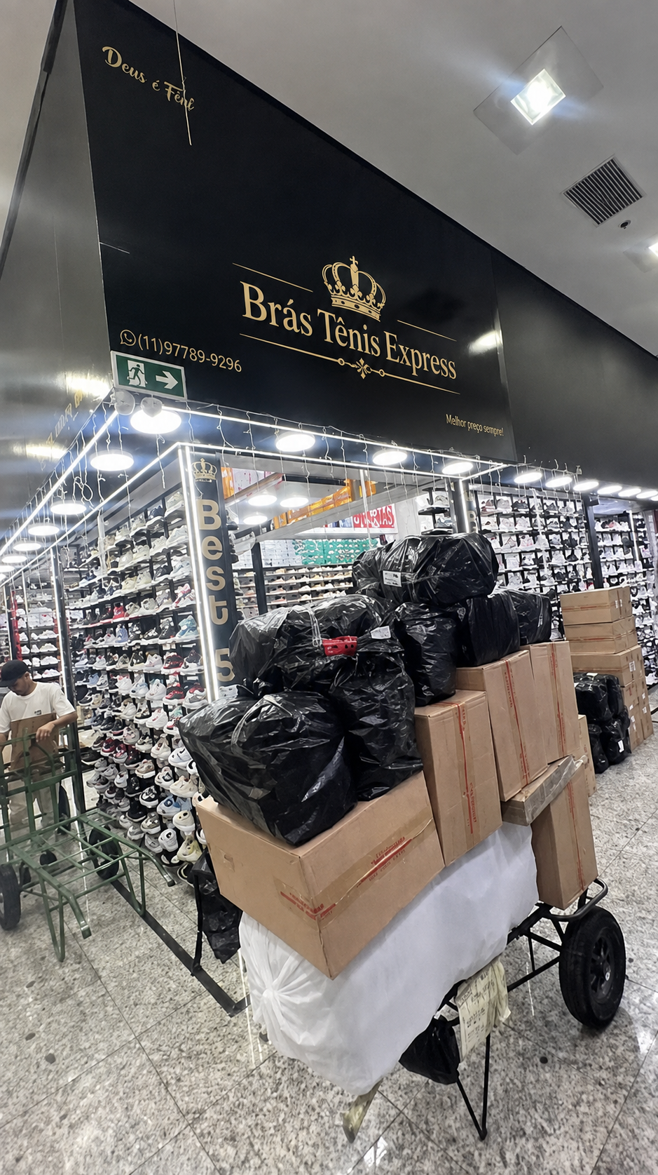 Fachada da loja Brás Tênis Express no Bom Retiro, São Paulo, com prateleiras cheias de tênis